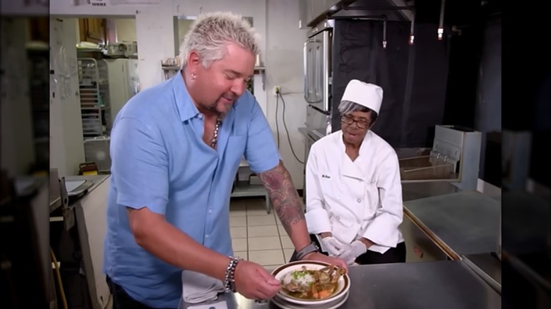 Guy Fieri with a chef in a restaurant kitchen about to taste a dish on Diners, Drive-Ins And Dives