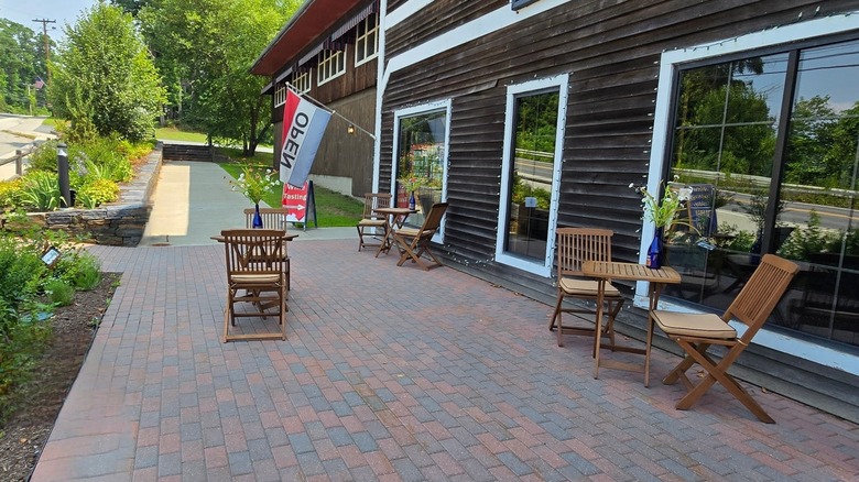 The front patio at Putney Mountain Winery and Spirits, with three tables outside the brown wooden building