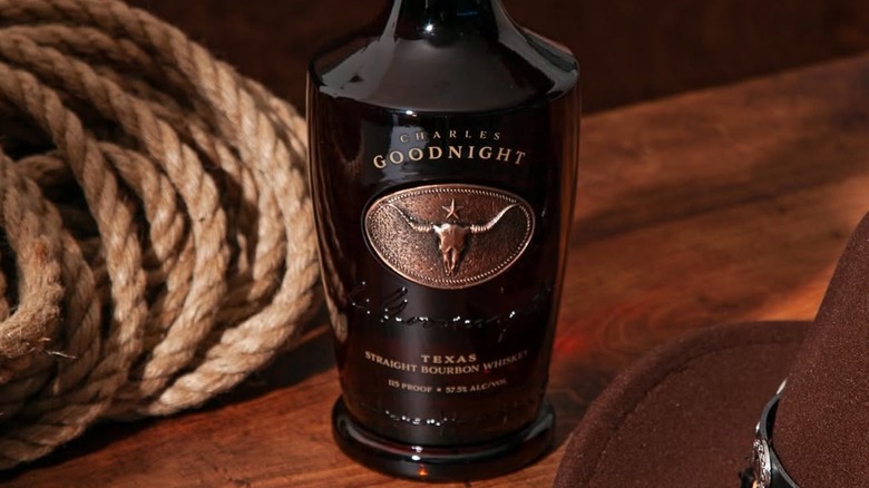 A bottle of Charles Goodnight bourbon shown next to rope and a hat