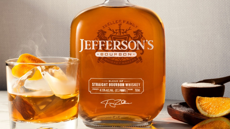A bottle of Jefferson's Bourbon shown with a cocktail on one side and fresh ingredients on the other