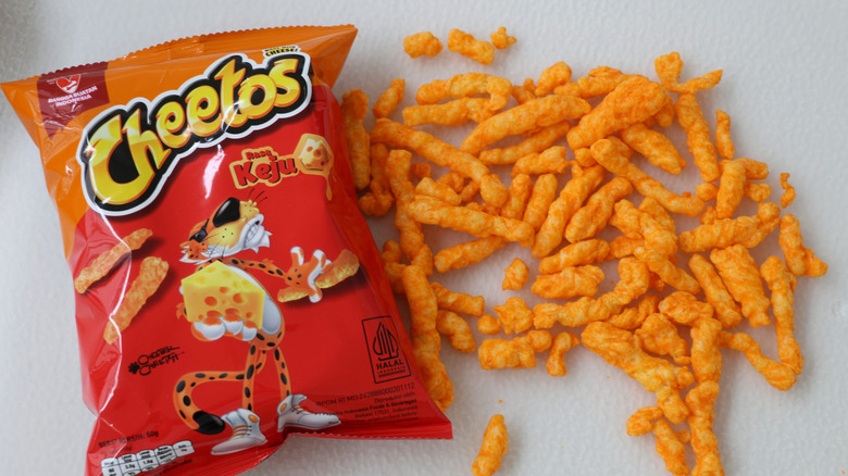 Cheetos in bag and scattered on a table