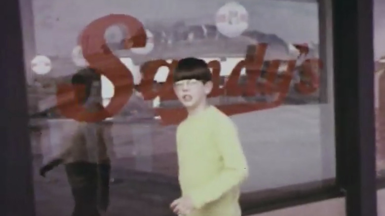 Young boy walking in front of Sandy's window