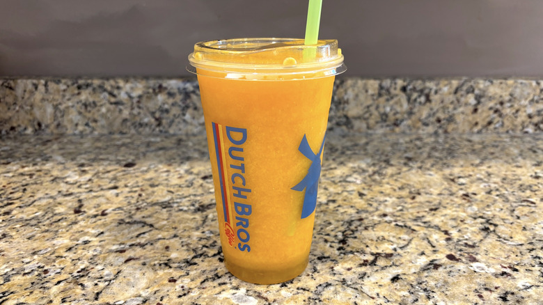 Dutch Bros mango smoothie on a marble countertop