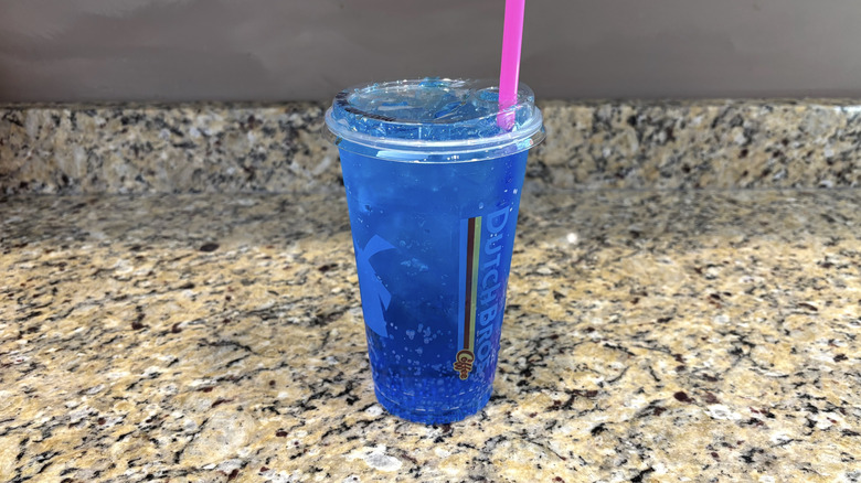 Dutch Bros blue raspberry sparkling soda on a marble countertop