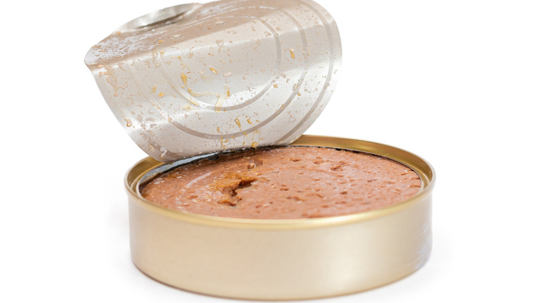 An open tin of pâté with a white background.