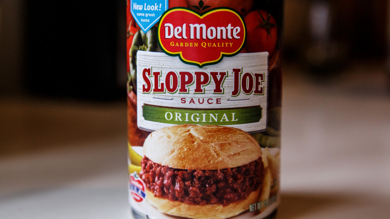 A close up of a can of Del Monte Sloppy Joe sauce with a brown background.