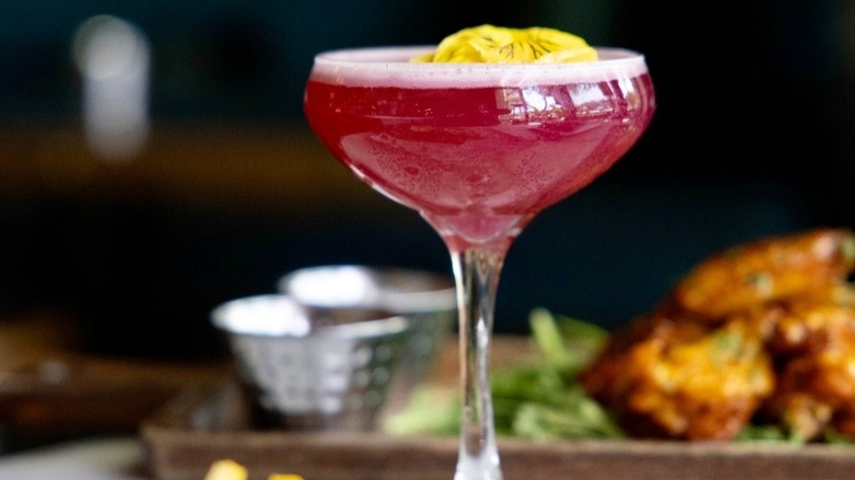 Pink cocktail with yellow flower decoration