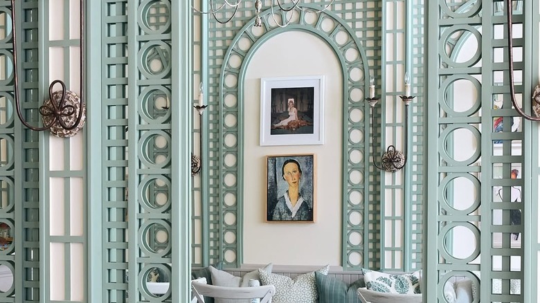 Something About Her's elegant interior with sage green trellises and two paintings