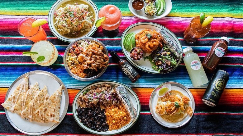 Margaritas, beers, juices, tacos, quesadillas on colorful Mexican tablecloth