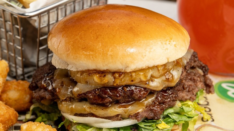 Burger with two patties and onions at a Wahlburgers