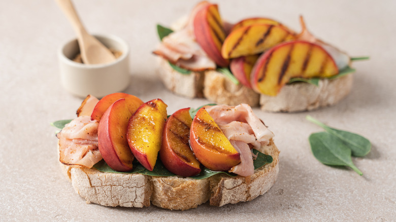 Charred peaches on meat on sourdough bread slices