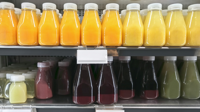 Bottles of juice lined up on two shelves