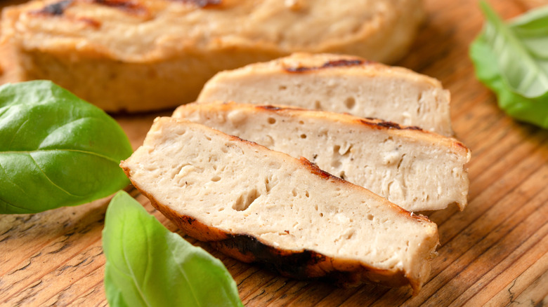 Vegan chicken slices on a wooden cutting board