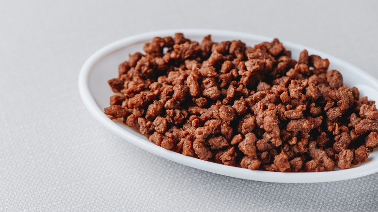 Vegan ground meat in a white bowl on a gray cloth