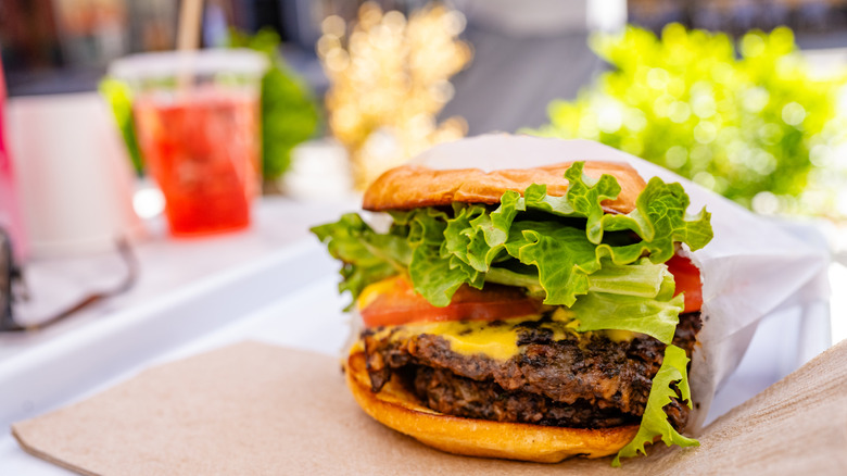 Vegan burger on a table with drinks in the background
