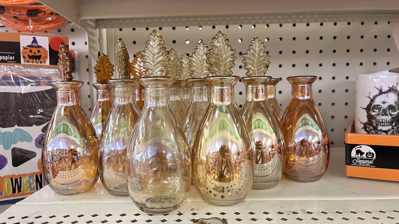 Shiny glass vessel with leaf topper