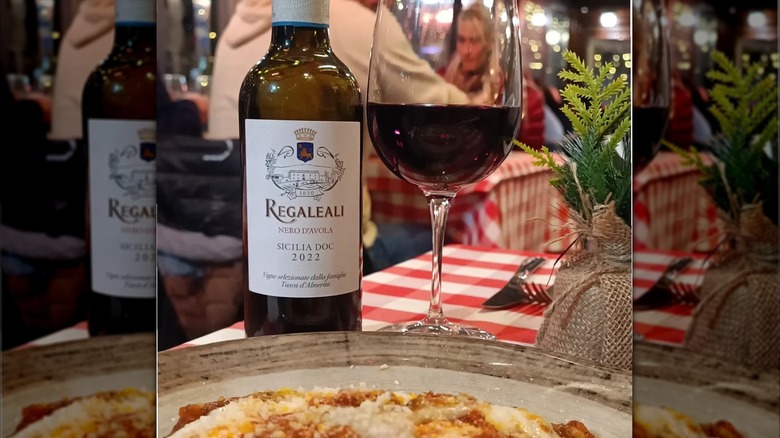 bottle and glass of red wine with dish