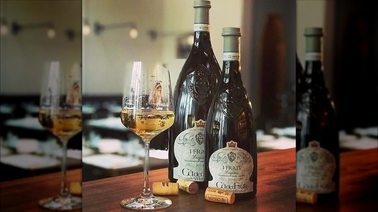 two bottles of Cà dei Frati 'I Frati' Lugana white wine with a glass