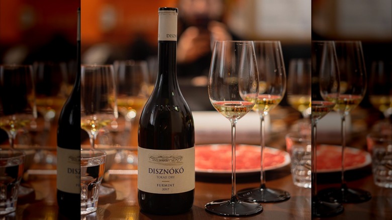 a bottle of Disznókő Tokaji Dry Furmint white wine with two glasses