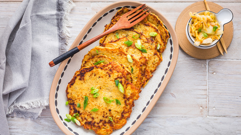 dish with Kartoffelpuffer next to small bowl of cabbage salad