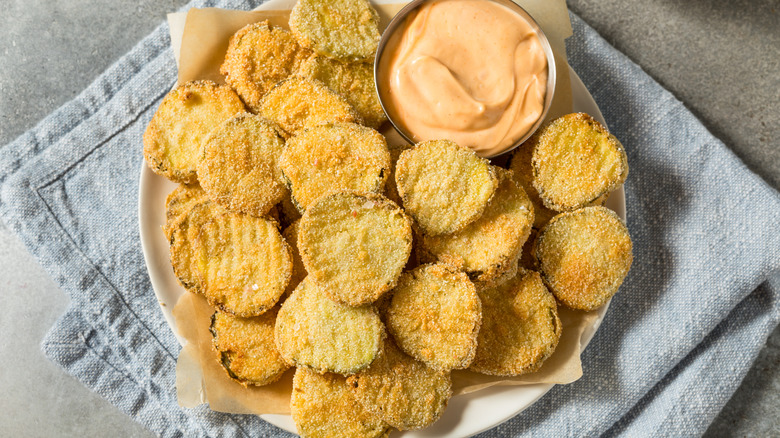 Deep fried pickles on plate with sauce