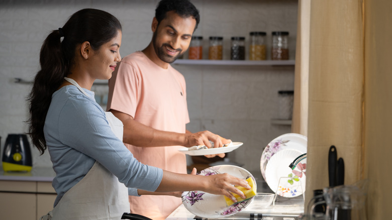 Couple washing dishes together