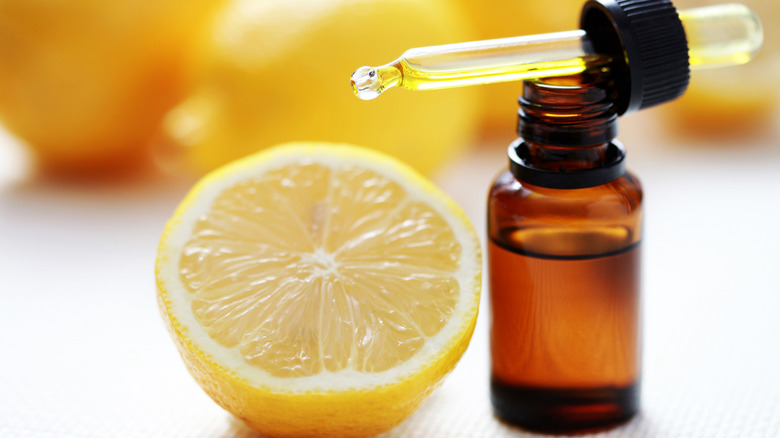Dropper bottle of lemon extract next to fresh lemon half