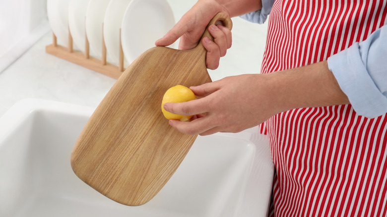 Rubbing lemon on wooden cutting board