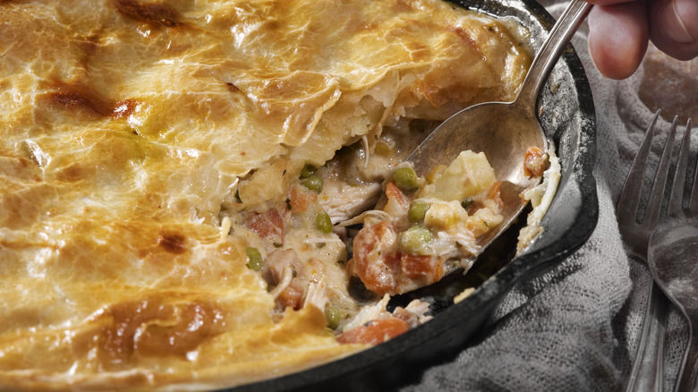 Spooning chicken pot pie out of skillet