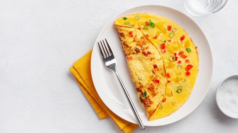 Vegetable omelet on white plate with fork