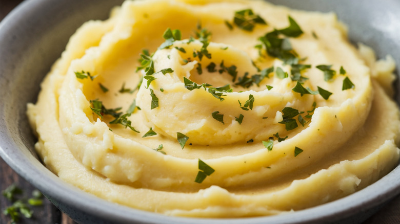 Close up of bowl of herb-topped mashed potatoes