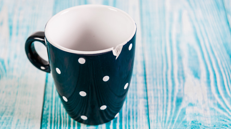 chipped ceramic cup on blue background
