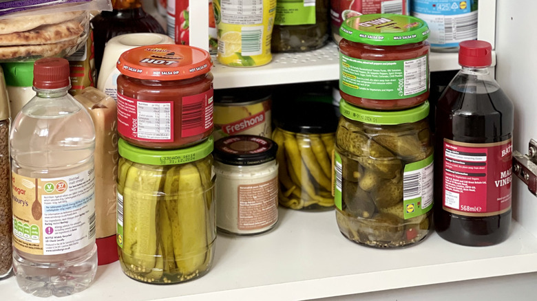 shelf with jars of food and bottles of cooking liquids