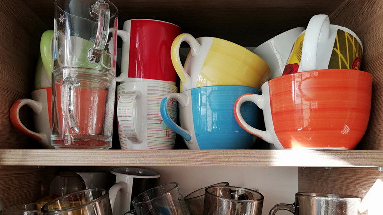 jumbled coffee mugs in cupboard