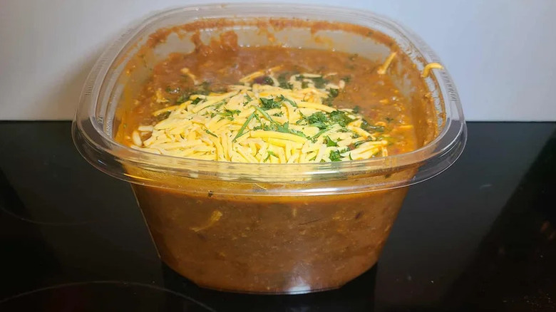 Plastic container of chili on counter