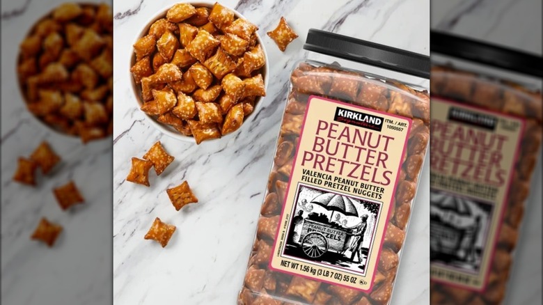 A tub and bowl of Kirkland Signature Peanut Butter Stuffed Pretzels on a white and grey marble table