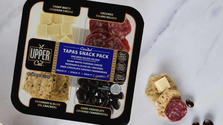 A package of Upper Cut Curated Tapas Snack Pack open on a kitchen counter