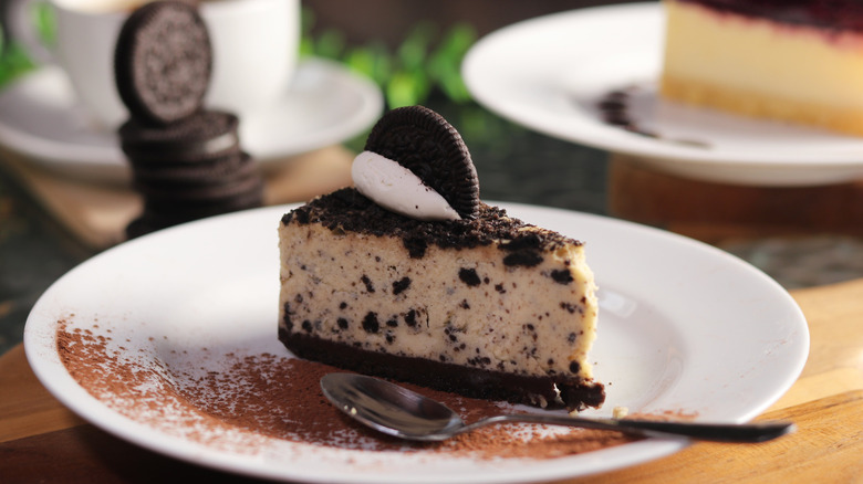 oreo cheesecake slice on a plate with spoon