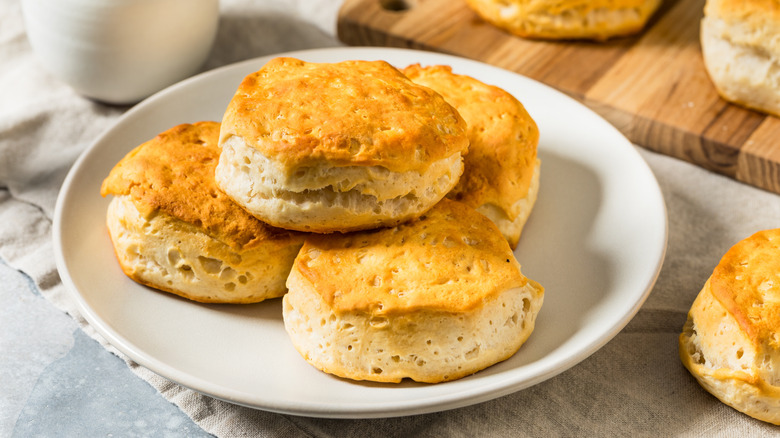 Pile of buttermilk biscuits on white plate