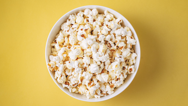 A bowl of popcorn on a yellow background