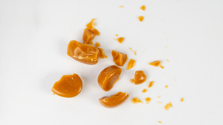 Broken caramel pieces on white background
