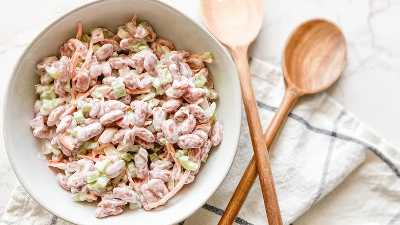 Creamy Kidney Bean Salad in white bowl with wooden spoons