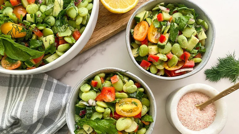 Fresh Herb Lima Bean Salad in three white bowls with bowl of salt