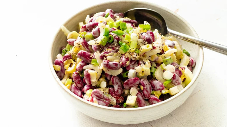 Hearty Kidney Bean Salad in white bowl with silver spoon