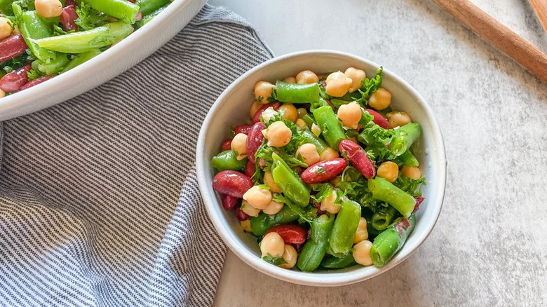 Three Bean Salad in small white bowl on striped towel