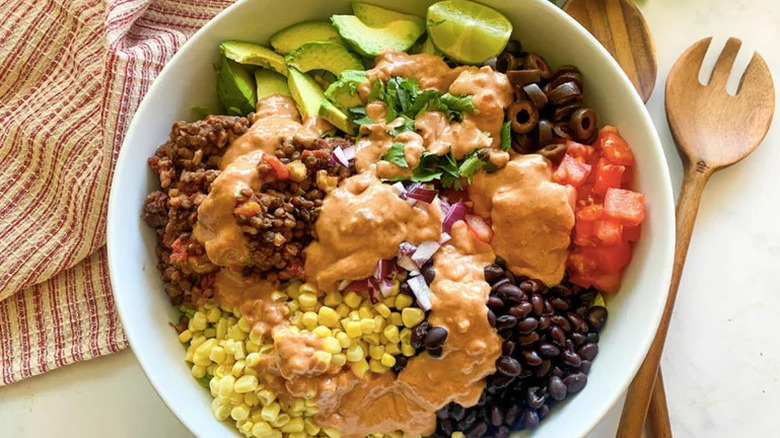 Vegan Taco Salad in large white bowl with wooden spoon