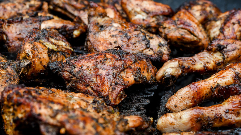 Several pieces of jerk chicken on a grill