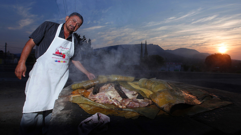 A man cooking barbacoa in an outdoor open fire pit