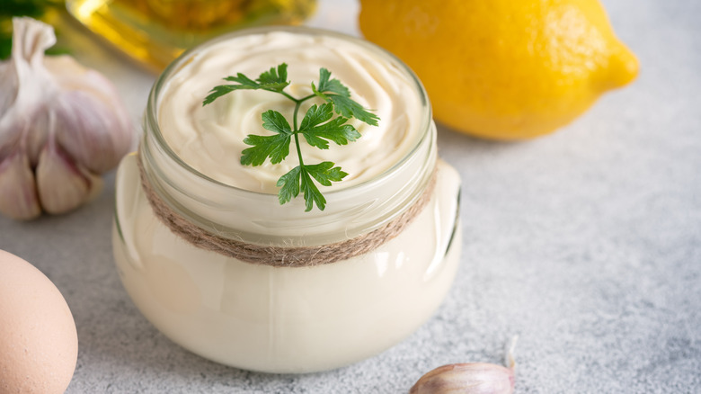 Aioli in glass jar with sprig of parsley