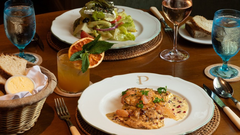 Table set with salads, cocktails, bread, and water glasses